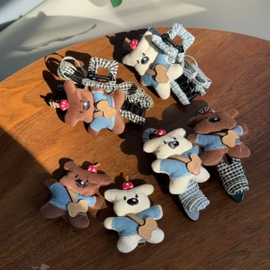 Détail de pinces à cheveux en peluche avec oursons, salopettes et tissu à carreaux