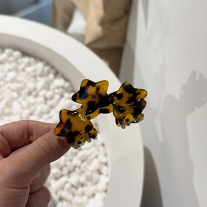 Close-up of tortoise shell star hair clips with gold France Handmade logo engraving