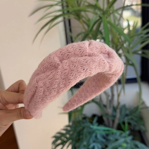 Roze gebreide haarband met zachte wolstructuur en een elegant breed ontwerp