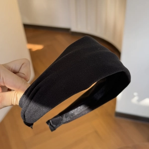 Detail of minimalist wide black velvet-textured headband with matte finish for daily wear