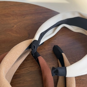 Close-up of wide velvet-touch headbands in cream, caramel, and coffee brown colors