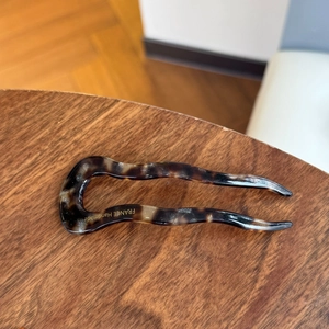 Detail view of acetate tortoise shell hair pin with golden handmade lettering