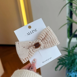 Barrette nœud en crochet beige avec bouton en bois vintage sur carte de présentation
