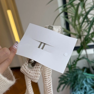 Détail de la pince à cheveux en tricot beige avec mécanisme à ressort en métal