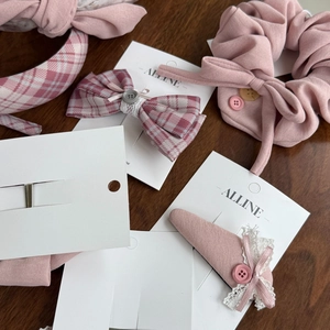 Detailansicht von rosa karierten Haarreifen und Spitzen-Accessoires auf Holzoberfläche