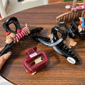 Detail of cute dog hair clips in black, brown and wine red on a wooden background