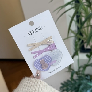 Detailed view of 3-piece hair clip set with pastel checks, polka dots, and a bear charm