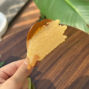 Détail d'une pince à cheveux en acétate d'ambre en forme d'épi de blé réaliste et élégant