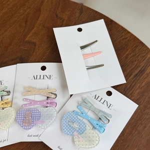 Close-up of heart-patterned hair clips with bear and rabbit motifs in pastel colors