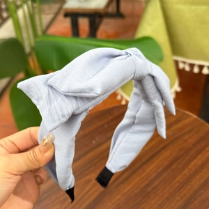 Détail du serre-tête bleu clair à pois avec grand nœud et embouts de protection