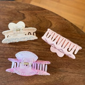 Close-up of heart-shaped rhinestone patterns on pastel acetate hair claw clips