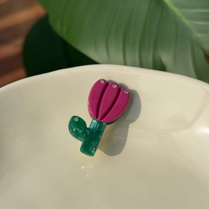 Detailed view of tulip acetate hair clip with rhinestones on a white ceramic tray