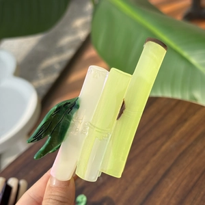 Détail de la pince à cheveux en acétate forme bambou avec feuille verte polie