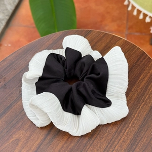 Detail of pleated black and white silk chiffon scrunchie with layered contrast design