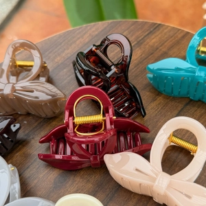 Macro shot of assorted colorful bow-knot hair claws with durable golden metal springs
