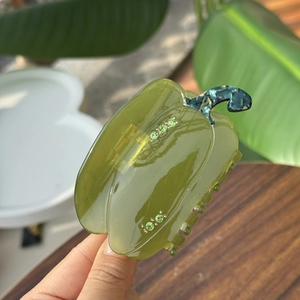 Détail d'une pince à cheveux poivron vert avec strass et texture marbrée