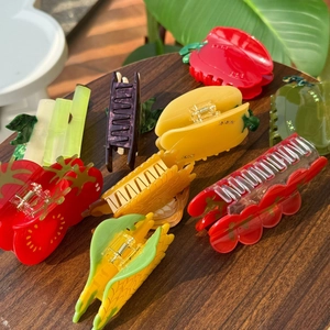 Collection de pinces à cheveux créatives en acétate en forme de légumes sur fond en bois