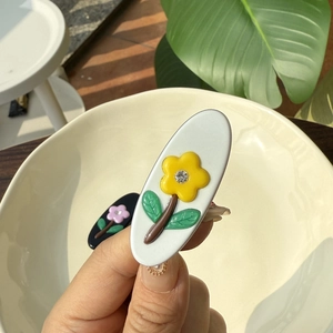 Barrettes à fleurs en acétate avec centres en strass en finitions noir et blanc