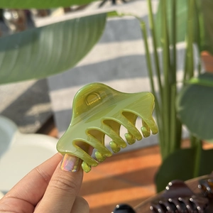Elegant 6cm lime green pointed claw clip with butterfly buckle on natural outdoor background