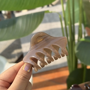 Detail of the 6cm translucent brown hair claw clip with a glossy finish and strong grip