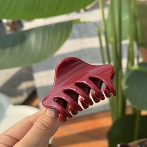 Macro view of wine red hair claw clip with glossy finish and durable shark tooth grip