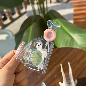 Detail of transparent acrylic hair claw featuring a cute green sea turtle and pink button