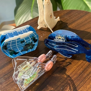 Detail of aquatic themed acetate hair clips featuring whale and sea turtle patterns