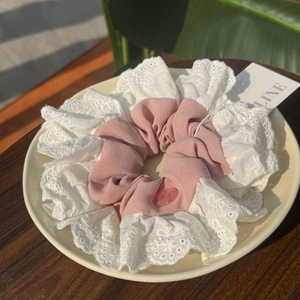 Chouchou en dentelle rose avec charm de cochon mignon sur une assiette en céramique
