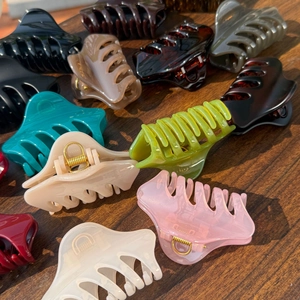 Close-up of assorted glossy resin butterfly hair claws with strong metal springs