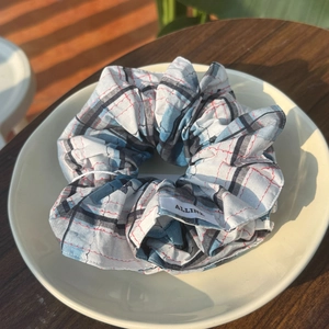 Chouchou à carreaux bleus avec strass et étiquette Alline dans un plat en céramique