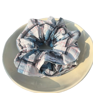 Chouchou en coton à carreaux avec strass et étiquette de marque sur une assiette