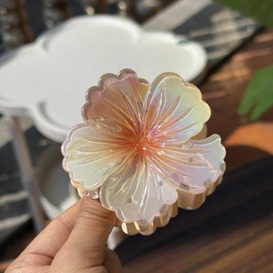 Detail of laser jelly flower hair claw clip with pearlescent finish and engraved petals