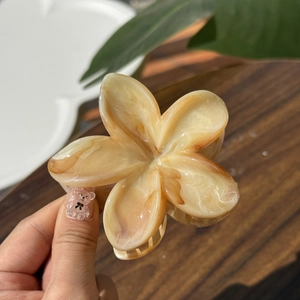 Dettaglio della molletta per capelli a forma di fiore con trama marmorizzata