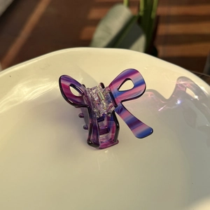 Pince à cheveux papillon à rayures violettes pour style Y2K sur plateau en céramique blanc