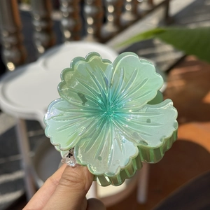 Detail of aurora green translucent flower hair claw clip with pearlescent laser finish