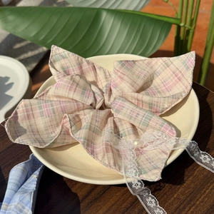 Pastel plaid scrunchie with lace trim and pearl bead on a ceramic display plate