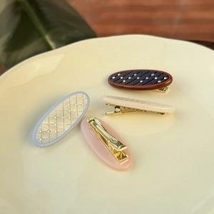 Lot de quatre barrettes ovales matelassées marron, bleu, rose et crème avec strass