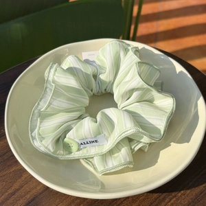 Striped flower button scrunchie in green and white fabric with ruffled edges