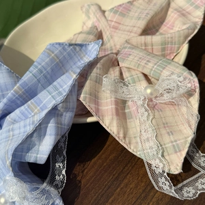 Close-up of pastel plaid fabric hair ties with white lace trim and pearl accents