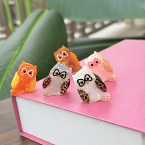 Lot de 5 barrettes hibou en acétate aux reflets nacrés sur un livre rose
