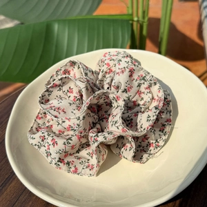 French vintage floral scrunchie in beige cotton with pink flowers on a ceramic plate