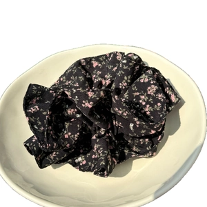 French vintage black floral scrunchie hair accessory displayed on a white ceramic plate