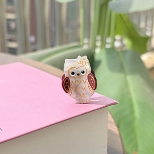 Détail de la pince à cheveux hibou en acétate avec texture nacrée et bordures dorées
