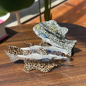 Détail de pinces à cheveux en forme de poisson avec motifs léopard et à pois
