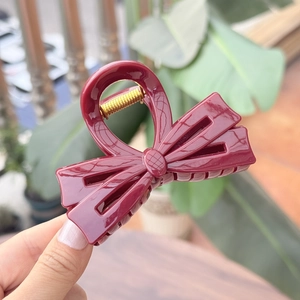 Vue détaillée de la pince à cheveux noeud papillon rouge vin en résine brillante