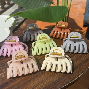 French style hair claw clips set in various colors displayed on a wooden table