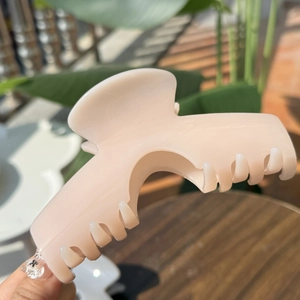 Élégante pince à cheveux 15cm en résine rose tendre avec grand arc tenue à la main