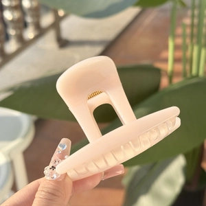 Gros plan d'une pince à cheveux fleur rose nude de 8cm avec finition en résine brillante