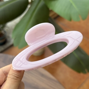 Detail view of the 10cm hollow oval hair claw clip in translucent pink resin