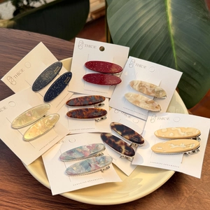 Detailed close-up of acetate duckbill hair clips in various star and marble patterns